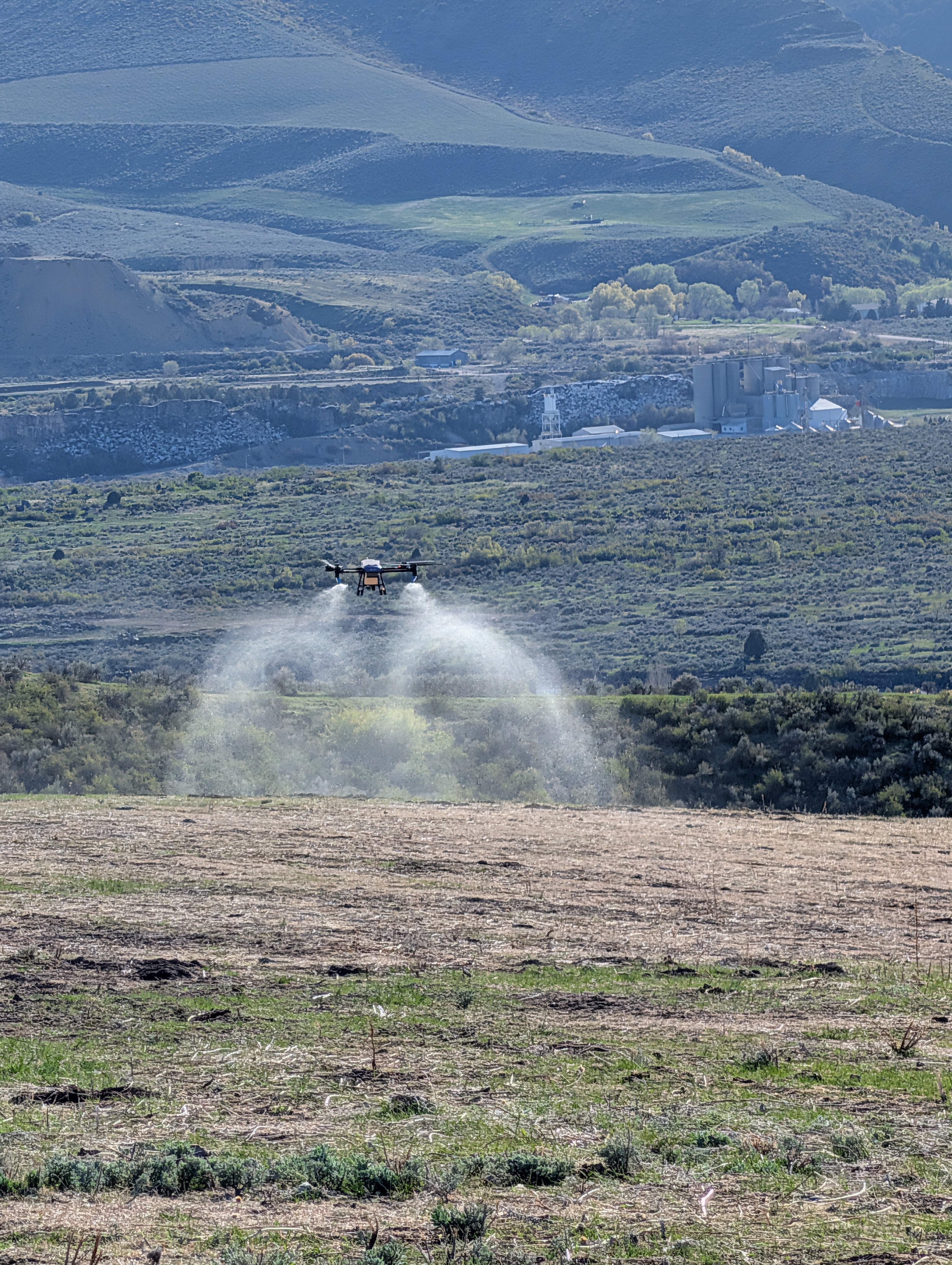Agricultural drone crop spraying over farmland